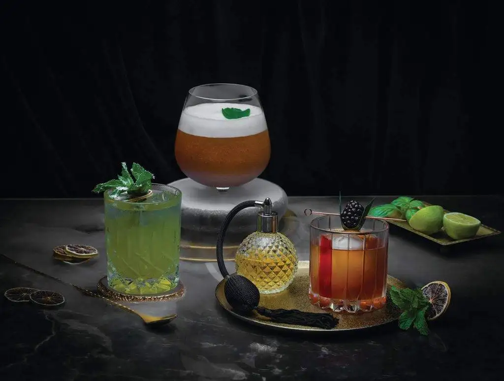 Elegant craft cocktail collection featuring mint mojito, old fashioned, and espresso martini with fresh garnishes and vintage atomizer