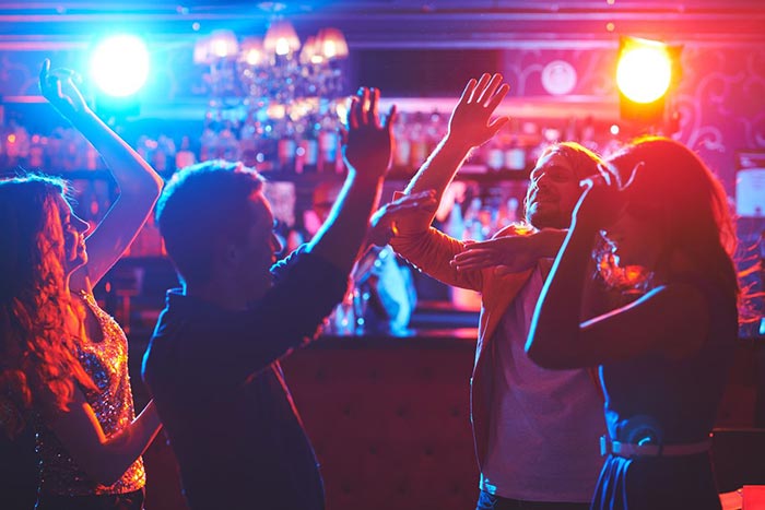 Vibrant party scene at Ashas Dubai restaurant with colorful lighting and people dancing, perfect for events and celebrations