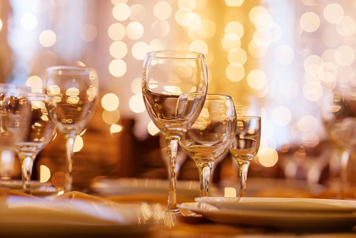 Elegant table setting with crystal wine glasses and warm ambient lighting for corporate events at Ashas Dubai restaurant